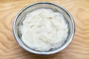 Submerge skeins of undyed yarn into the bowl